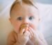 selective focus photography of baby holding wooden cube